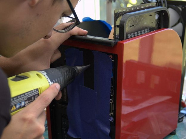 Image of Josiah Fast working on Spirit of Motion drilling a hole for the power button 