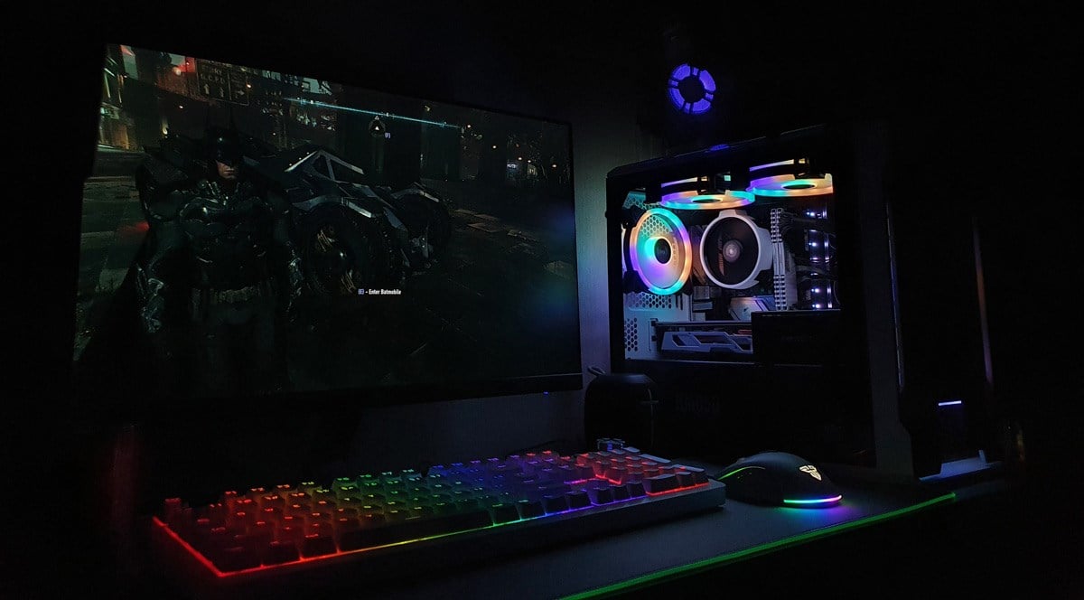 A gaming PC setup in low lighting with various RGB illumination effects.