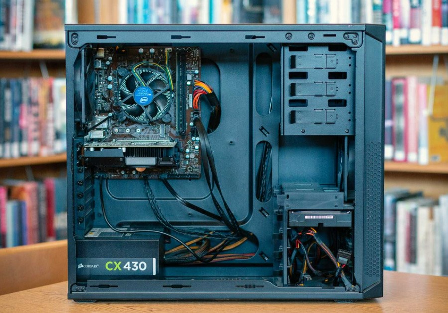 A tower PC with the side removed to show the components, including the power supply and cabling.