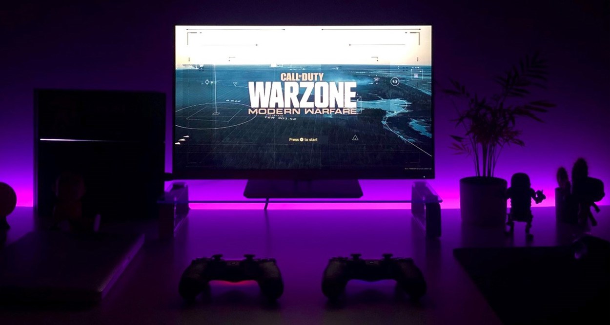 Purple RGB lit gaming PC with Warzone Modern Warfare loading screen.