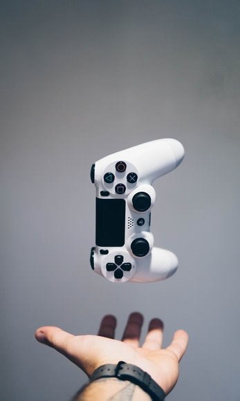A Playstation 5 controller floating above an outstretched hand.