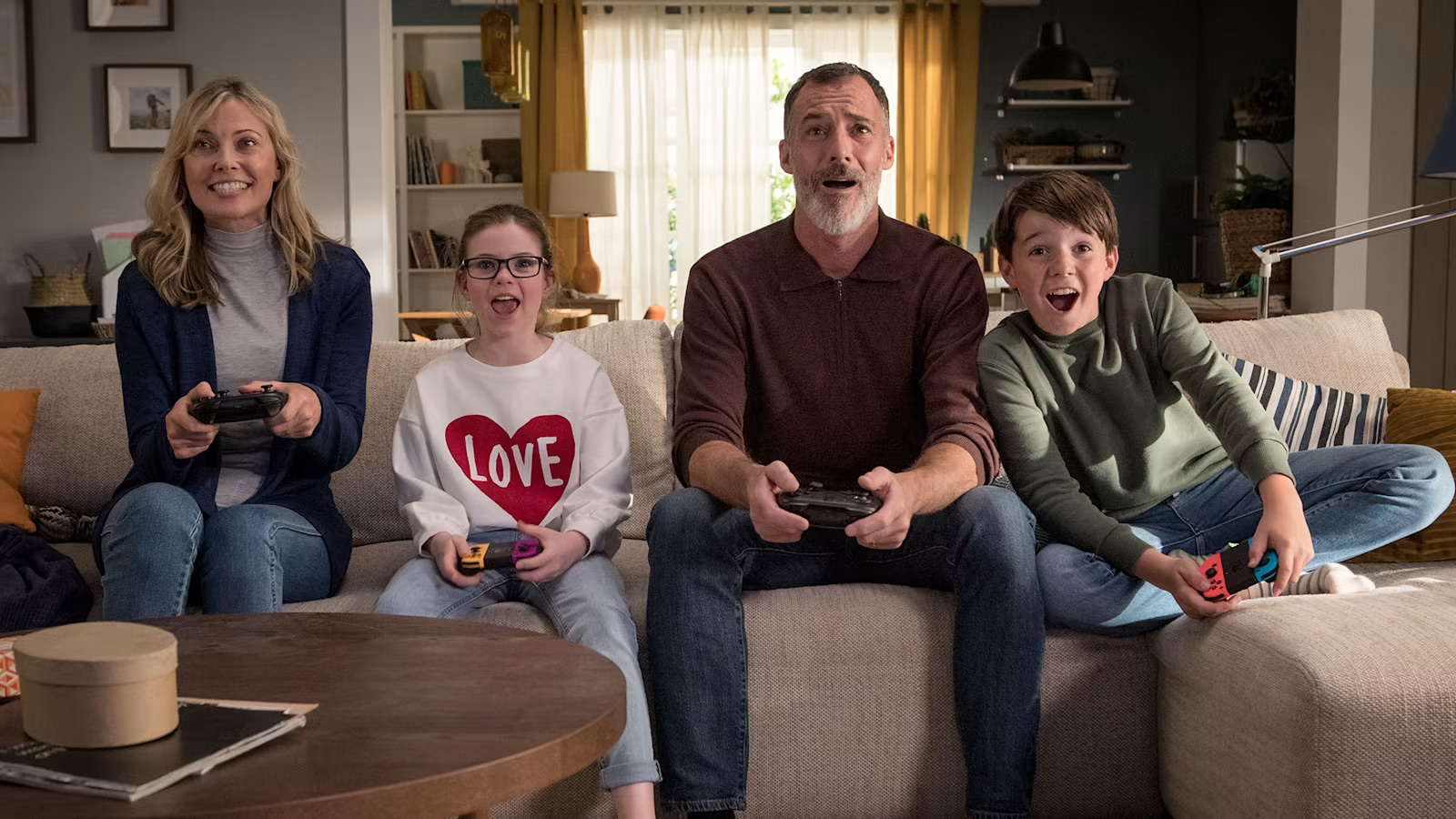 A family of mother, daughter, father and son all playing Nintendo Switch.