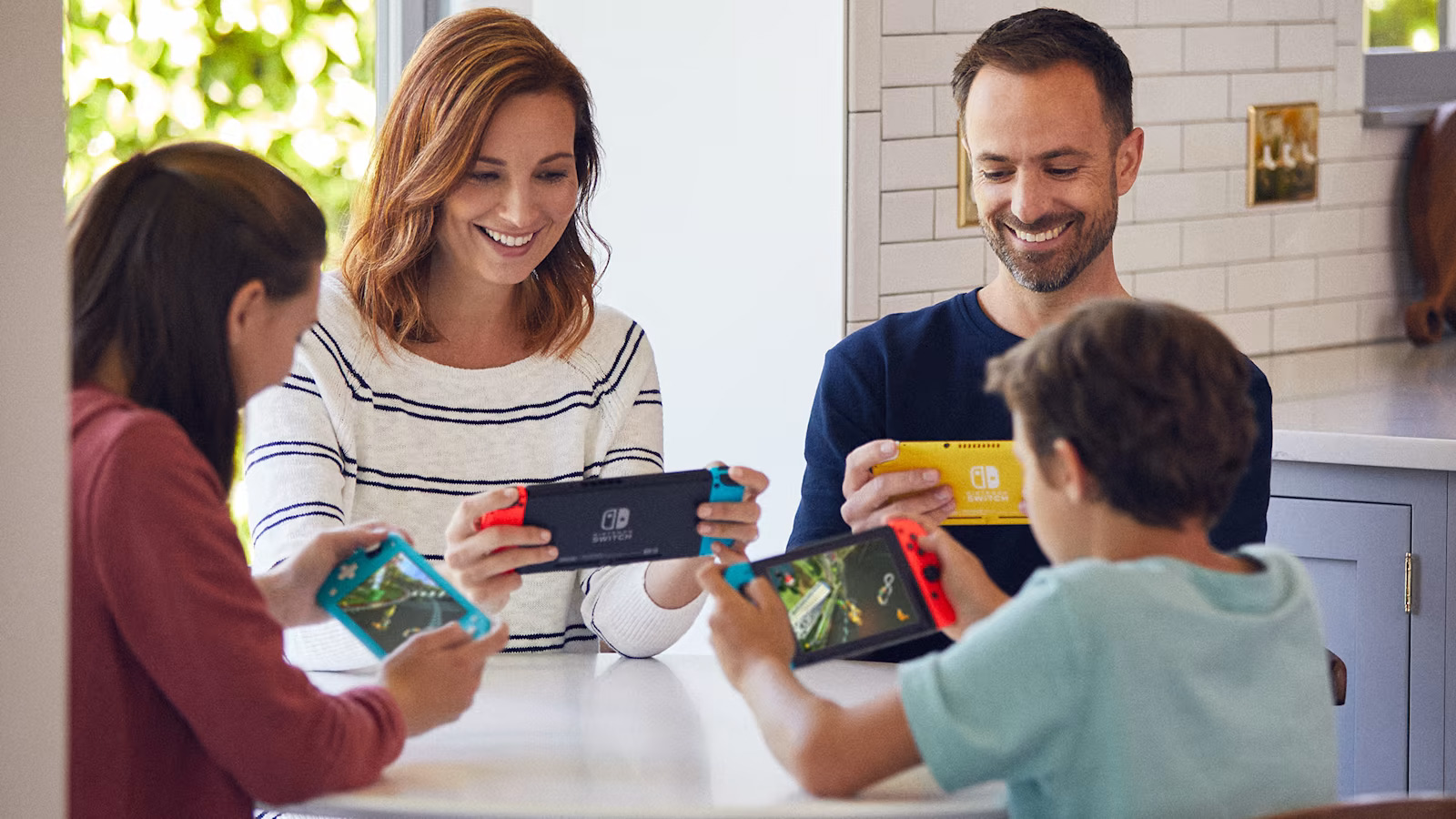 A family of mother, daughter, father and son all playing Nintendo Switch.