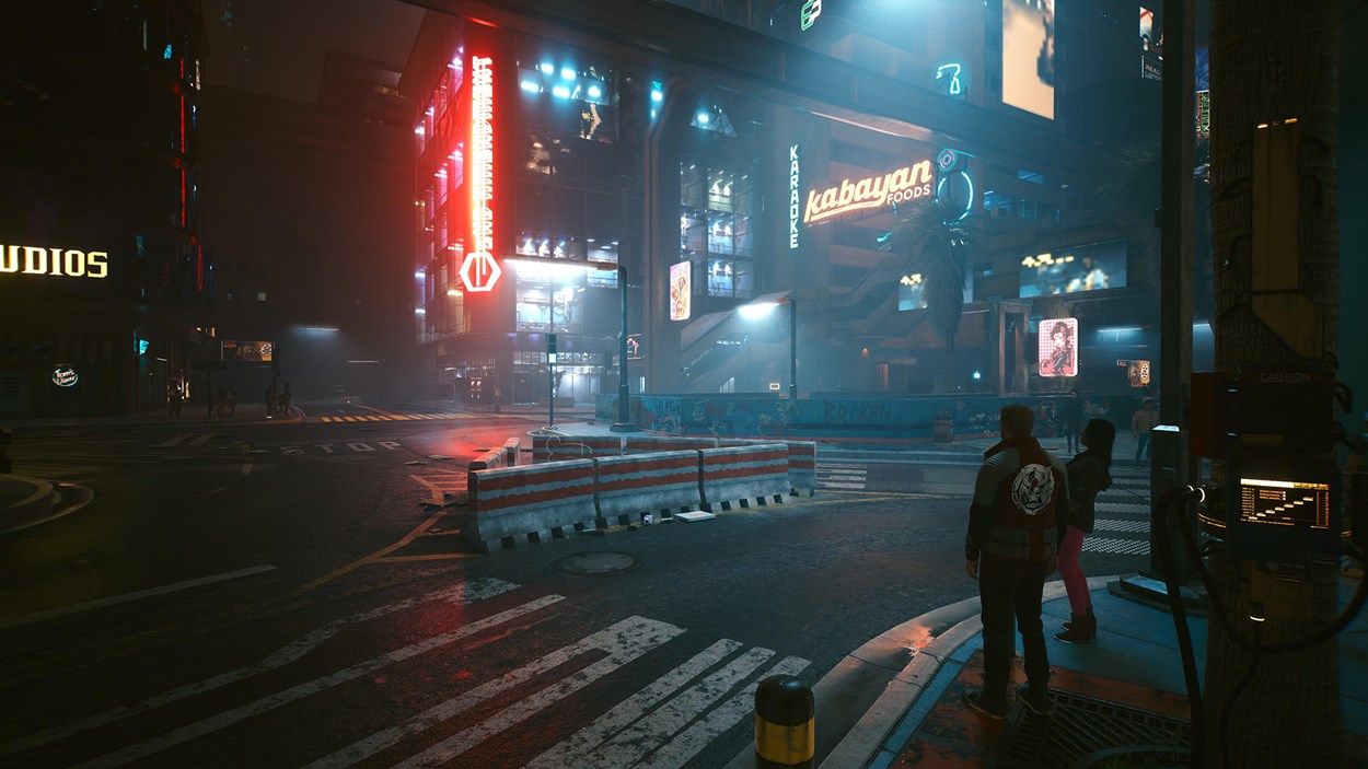 Nighttime view of a vibrant futuristic city street, illuminated by neon signs and storefronts, with pedestrians and barricades adding life and depth to the urban environment.