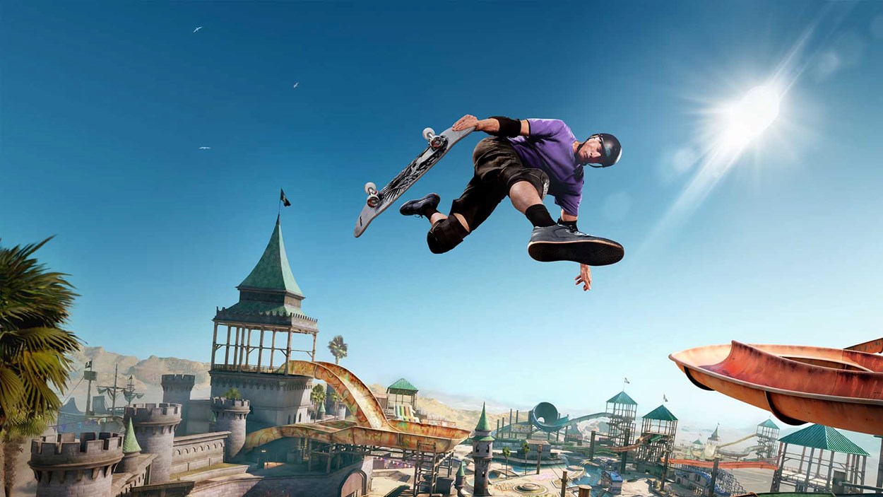 Skateboarder mid-air performing a grab trick over a castle-themed skate park with blue skies and bright sunlight.
