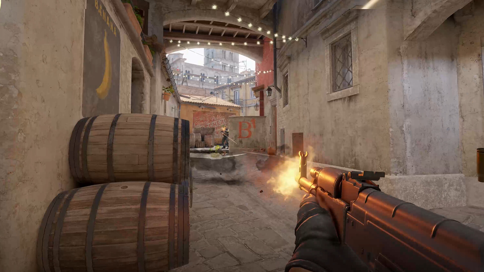 A first-person gameplay scene from Counter-Strike 2 showing a player firing a rifle down Banana on Inferno towards the B site.