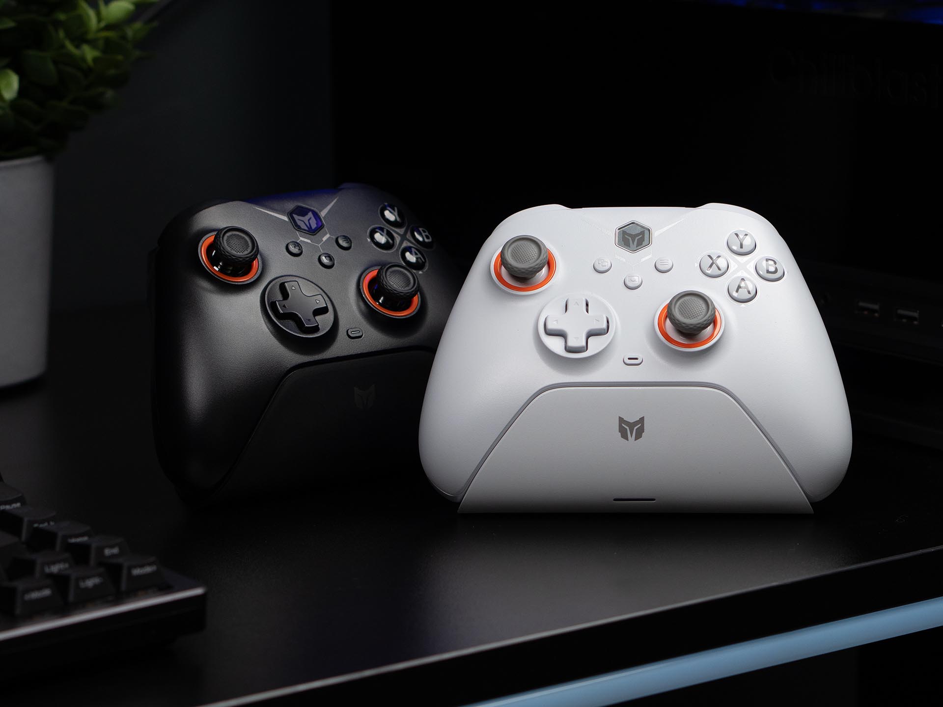 Black and white BIGBIG WON Gale Hall wireless controllers side by side on a gaming desk, showcasing their sleek design with orange accents and modern styling.