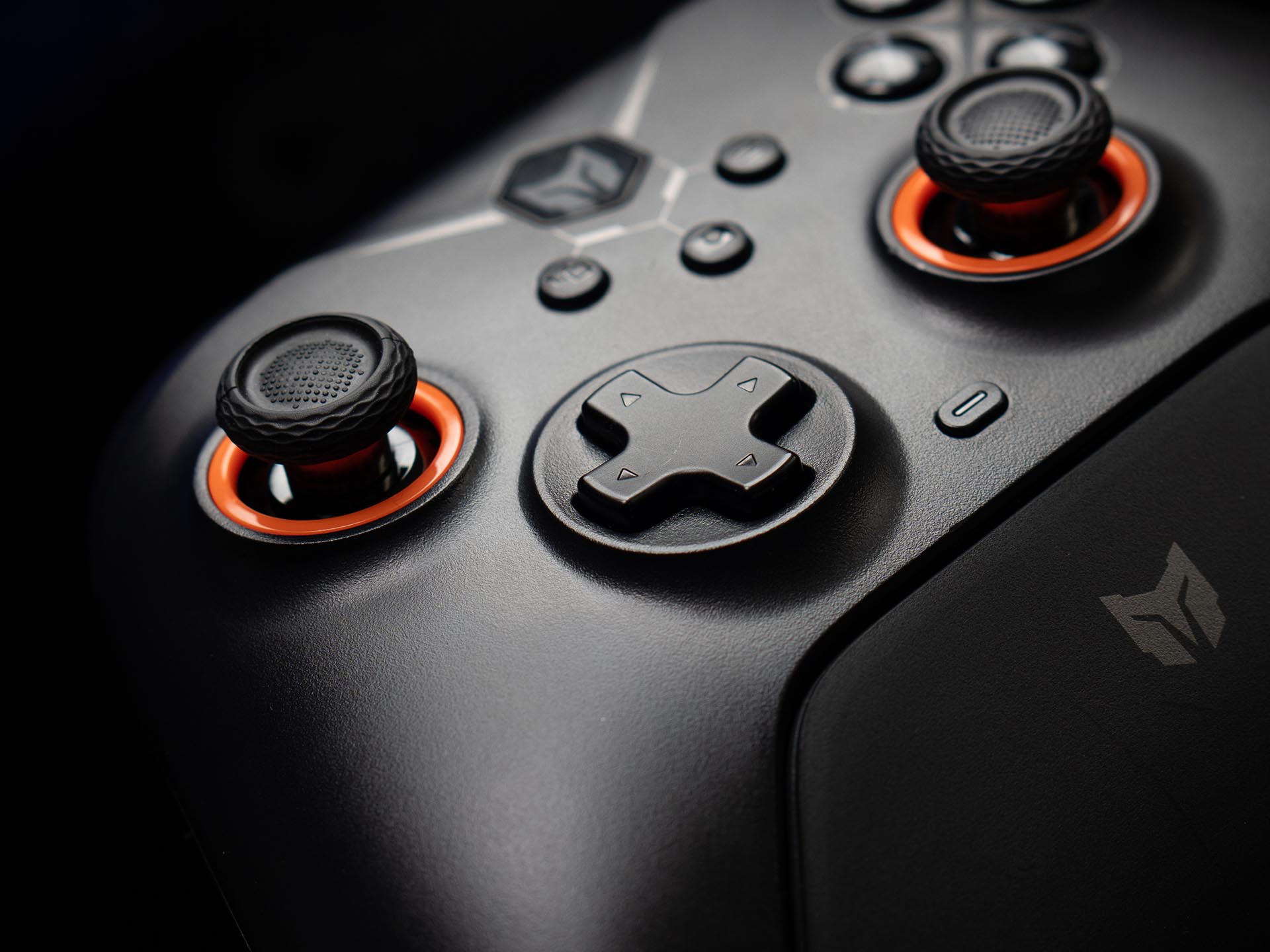 Close up of the BIGBIG WON Gale Hall controller showing Hall effect thumbsticks and textured D pad with orange accents.