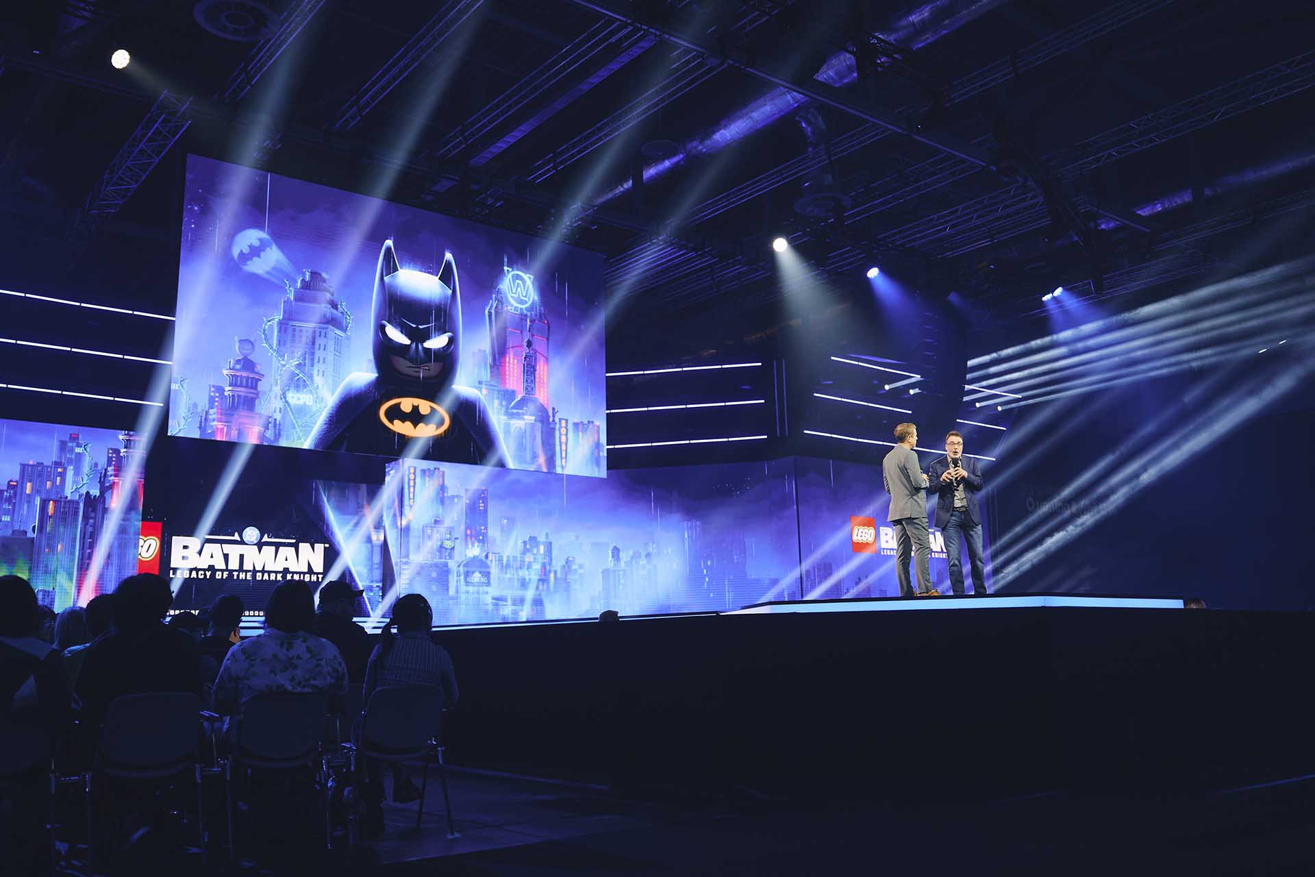 Presentation of Lego Batman: Legacy of the Dark Knight at Gamescom 2025, with speakers on stage and a large screen showing Lego Batman.