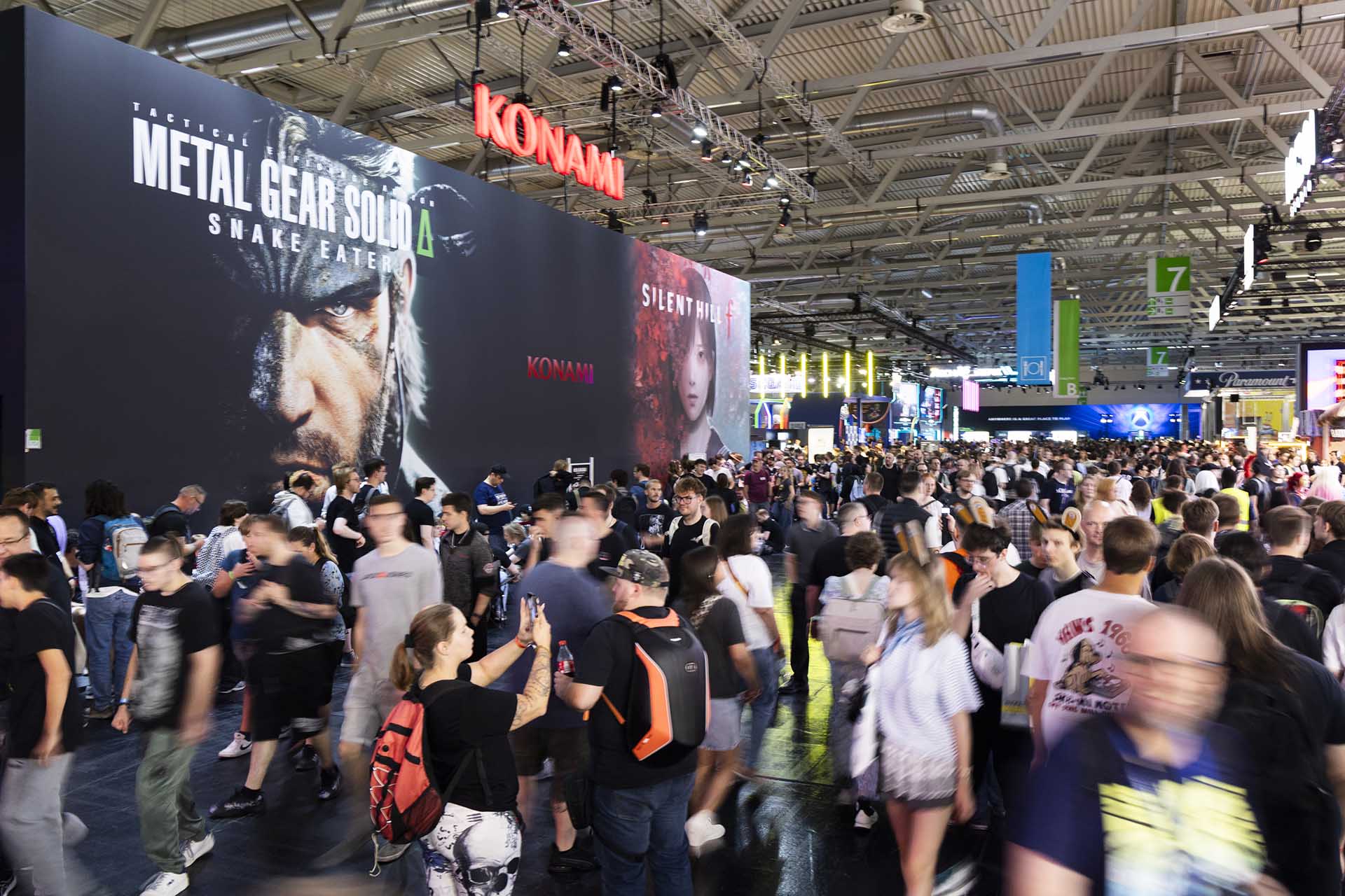 Gamers crowding the Konami booth at Gamescom 2025, featuring giant displays for Metal Gear Solid ?: Snake Eater and Silent Hill f.
