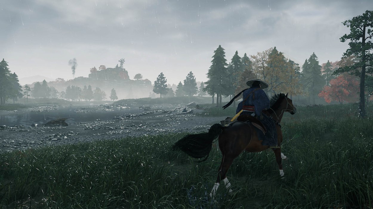 A lone samurai rides a horse through a lush, rain-soaked landscape, dressed in traditional attire with a straw hat. The scene is misty and atmospheric, with a river flowing beside them and a distant settlement with a windmill rising through the fog. The surrounding trees display a mix of green and autumnal hues, adding to the immersive open-world exploration setting of Rise of the Ronin.
