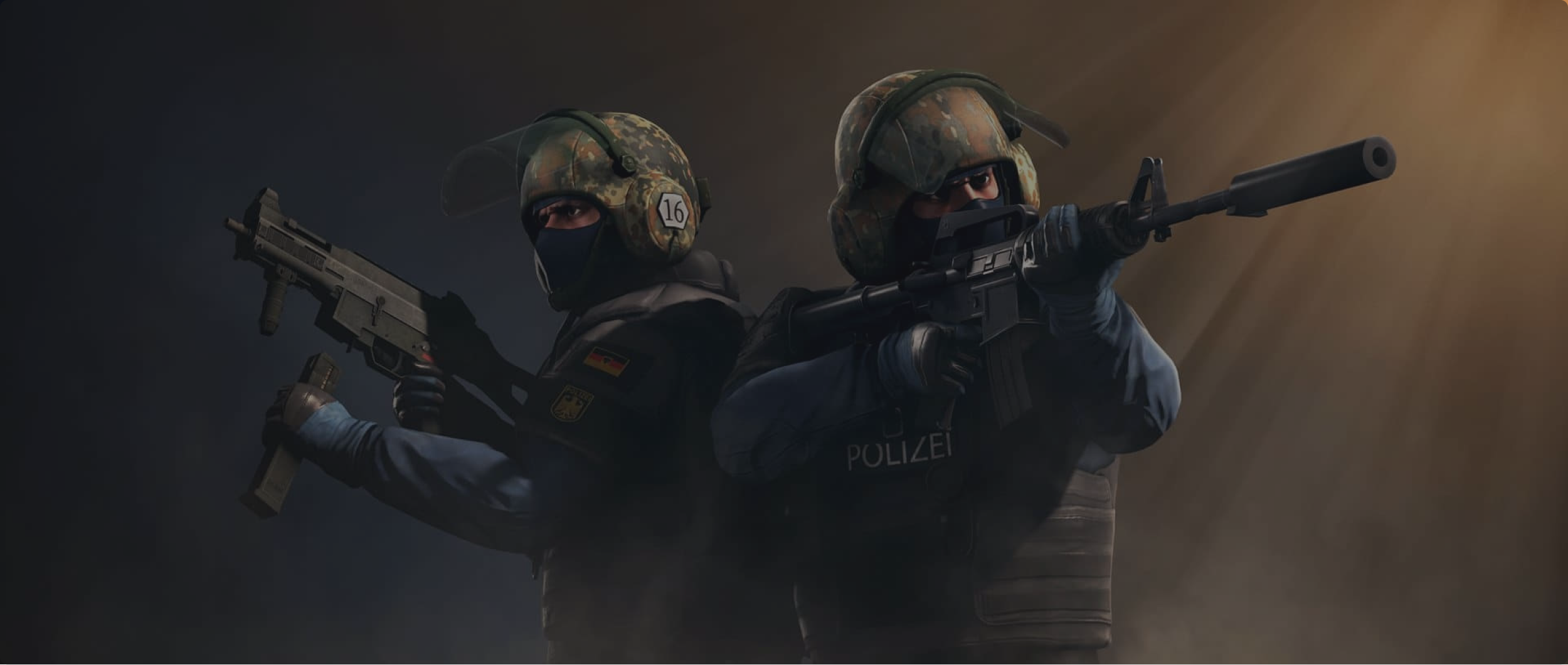 Two police officers in body armour, one holding an assault ridle and the other a sub machine gun